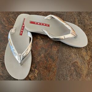Women’s Prada silver sport gold raised logo flip flop sandals. Size 36 (US-6)